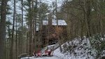 WOODED VEIW OF CABIN WITH SNOW DUSTING 